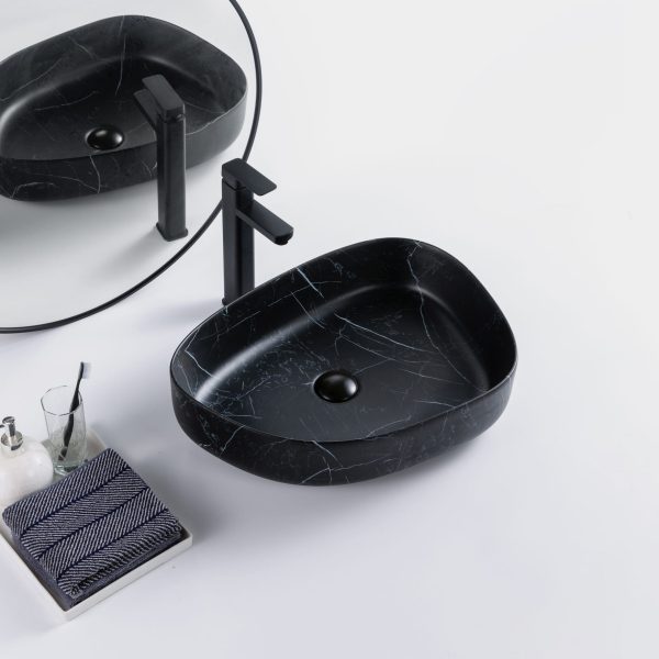 Stijlvolle badkameropstelling met een zwart marmeren waskom, een zwarte kraan en een grote ronde spiegel.