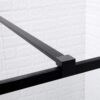 Detail van een zwarte metalen steunbalk bevestigd aan een glazen douchewand.