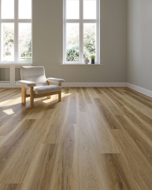 Een woonkamer met grote ramen, een pvc vloer, een witte stoel met houten poten in het midden en op de vensterbank staat een plantje. van Sanimaster