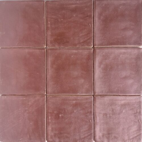 Wandtegel Bordeaux Metallic 13x13 Close-up van negen vierkante, matte, donkerroze tegels die samen een vierkant patroon vormen.