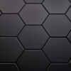 Wandtegel Hexagon Onda mat zwart Close-up van zeshoekige, zwarte tegels met een matte afwerking, gerangschikt in een honingraatpatroon.