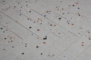 Witte visgraat tegels met graffiti stippen 2 | Wandtegel Terrazzo Mat Grijs 7,5x30 | Sanimaster