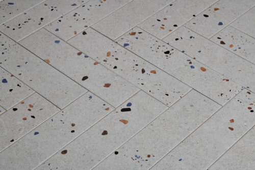 Witte visgraat tegels met graffiti stippen 2 | Wandtegel Terrazzo Mat Grijs 7,5x30 | Sanimaster