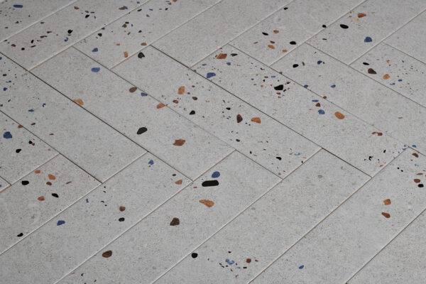 Witte visgraat tegels met graffiti stippen 2 | Wandtegel Terrazzo Mat Grijs 7,5x30 | Sanimaster